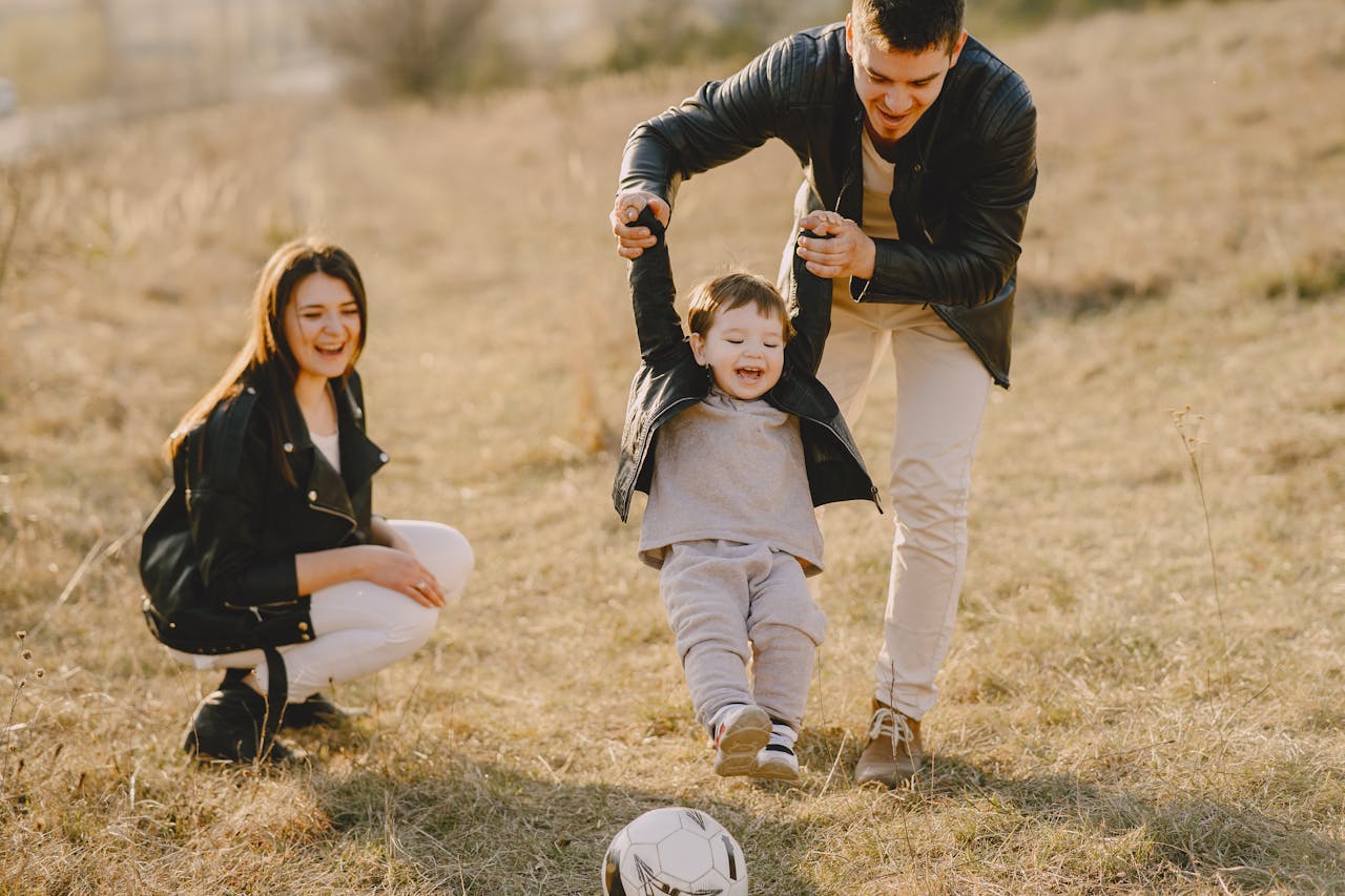 about-01 Family enjoying playful soccer game outdoors, capturing joyful moments.